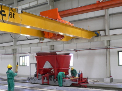 Concrete distributor crane feeding hollow core equipment at Nael Cement Products, Al Ain